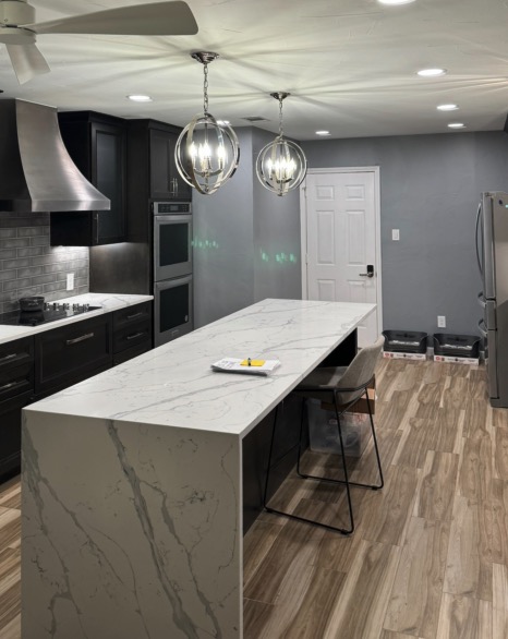 remodel image of a modern kitchen with stone countertop, light fixtures and stove